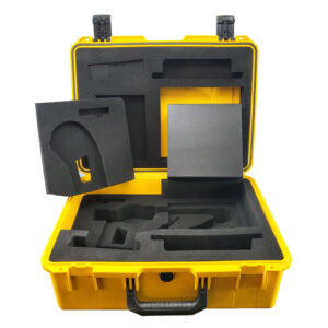 An open yellow carry case with a black handle, displaying dark gray foam and a small accessory box.