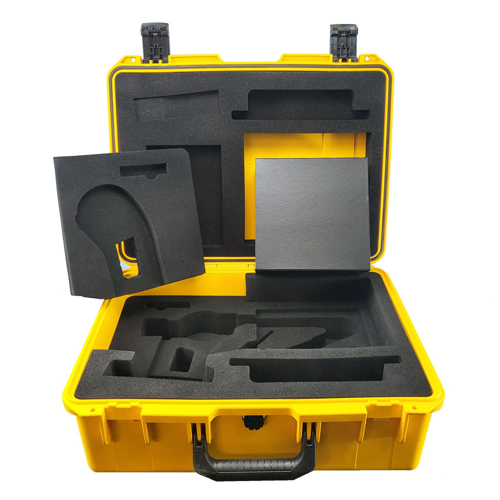 An open yellow carry case with a black handle, displaying dark gray foam and a small accessory box.